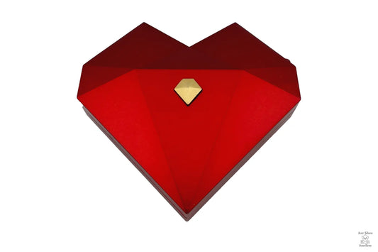 Three heart-shaped ring gift boxes in white, green, and red, with gold accents, displayed in an open presentation box.