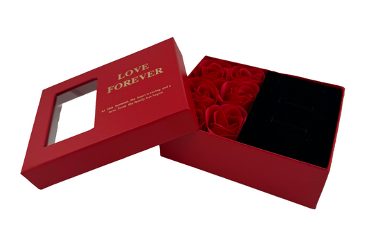 A red jewellery box with a gift arrangement of six roses, accompanied by a matching presentation bag with the text 'LOVE FOREVER' printed on it.
