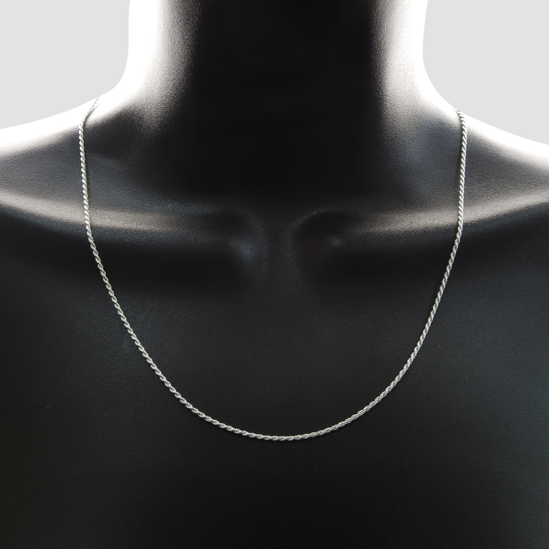 Silver chain necklace on a mannequin with a minimal background