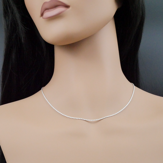 Mannequin wearing a silver necklace against a neutral background