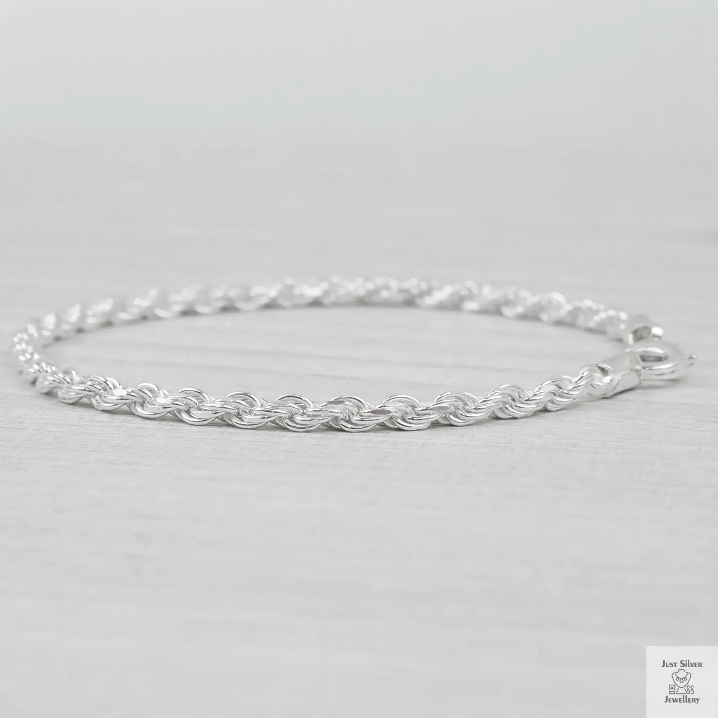 Silver rope bracelet on a light grey background
