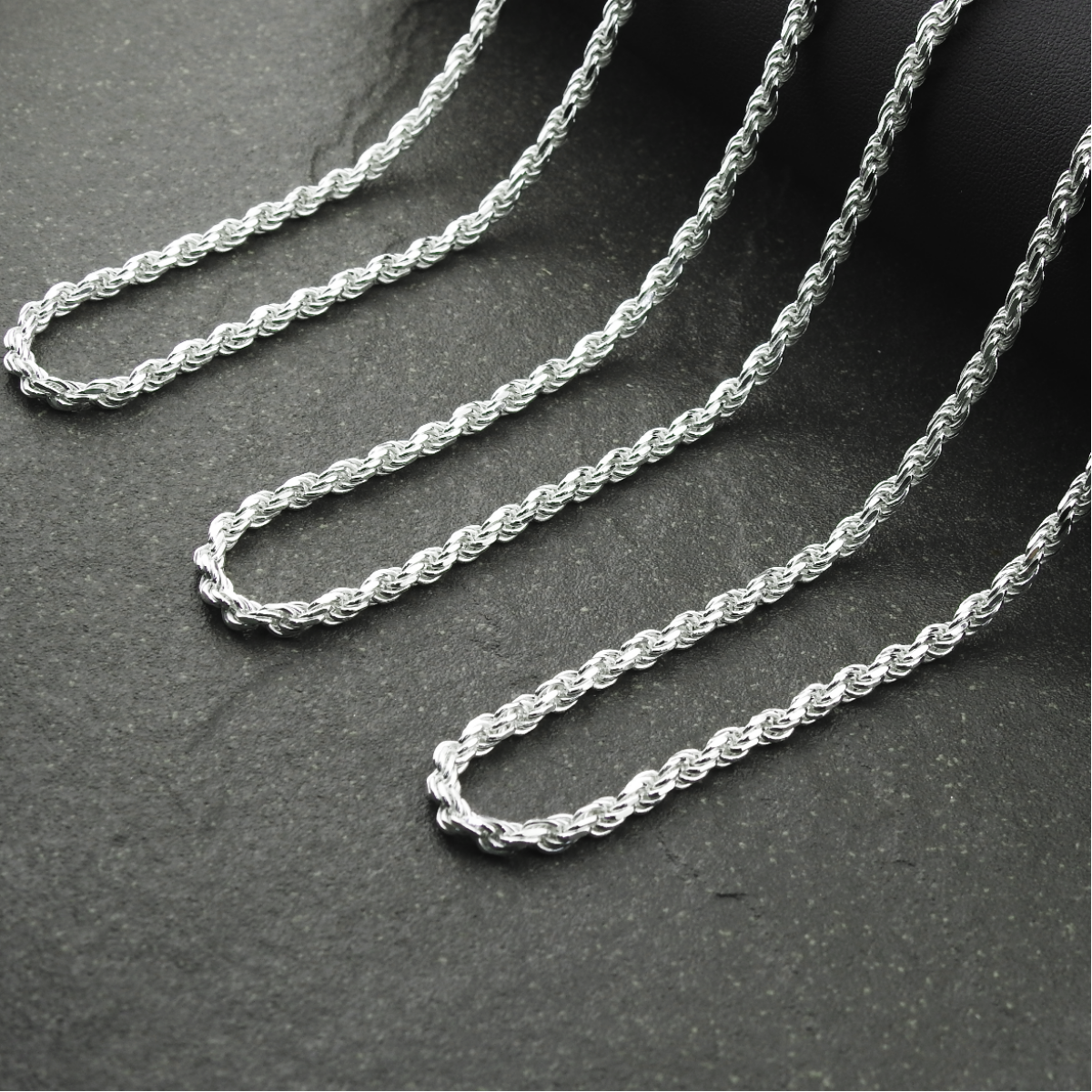Silver rope chain on a dark gray surface