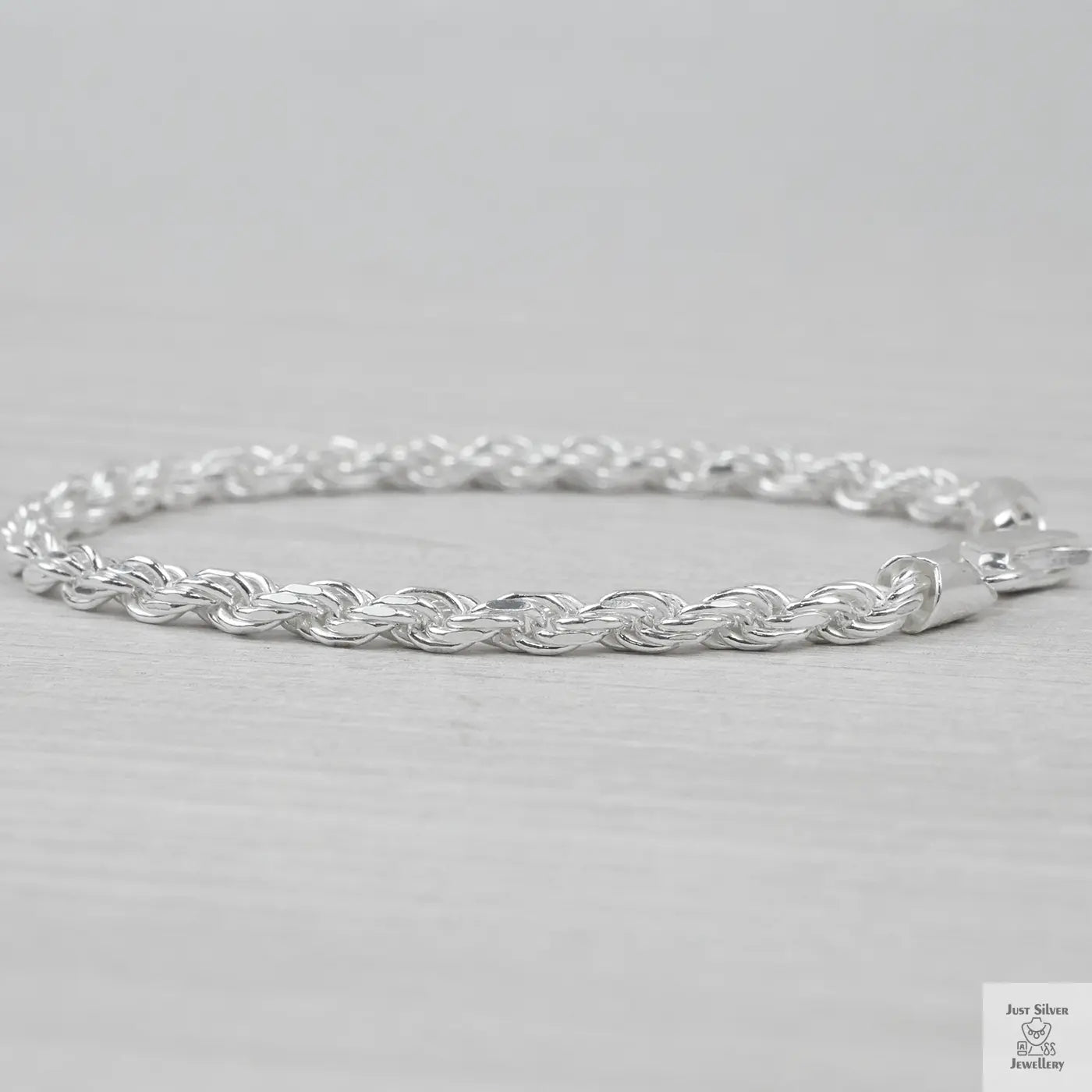 Silver rope bracelet on a light grey background