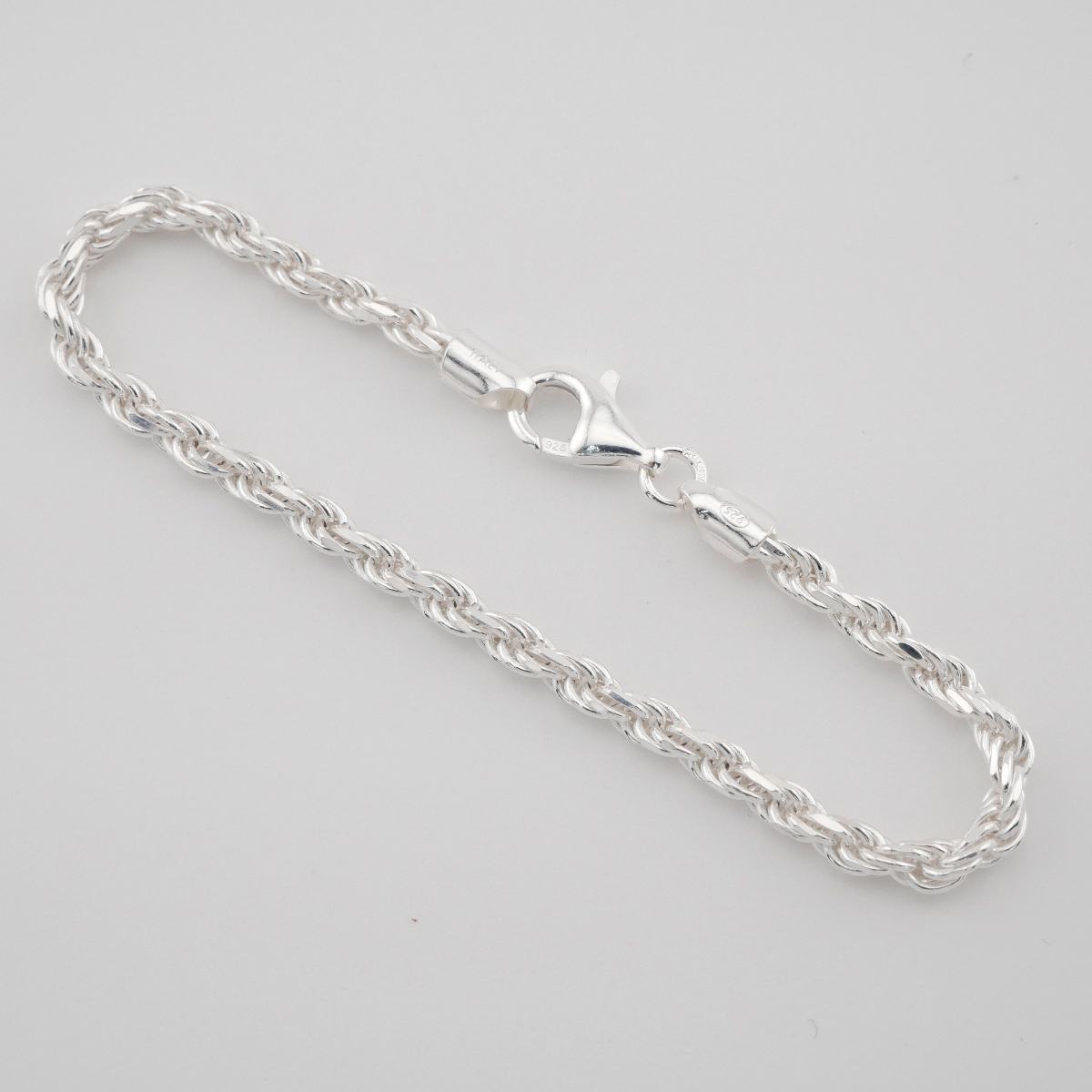 Silver chain bracelet on a light gray background