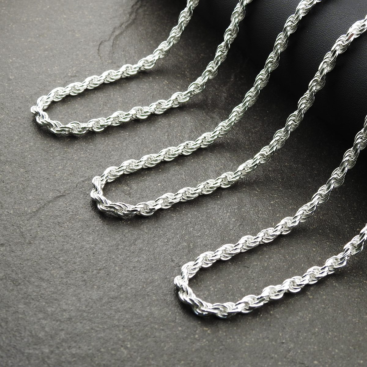 Silver rope chain on a dark surface