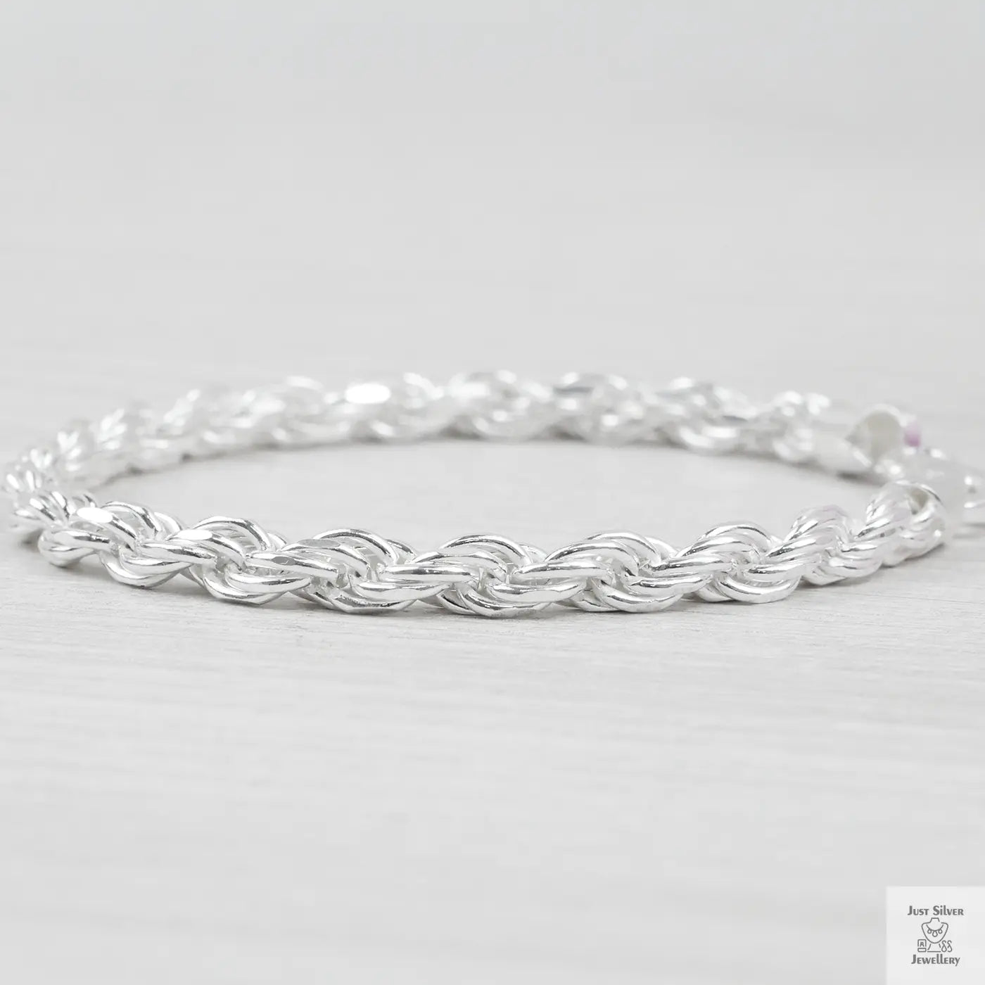 Silver rope bracelet on a light grey background
