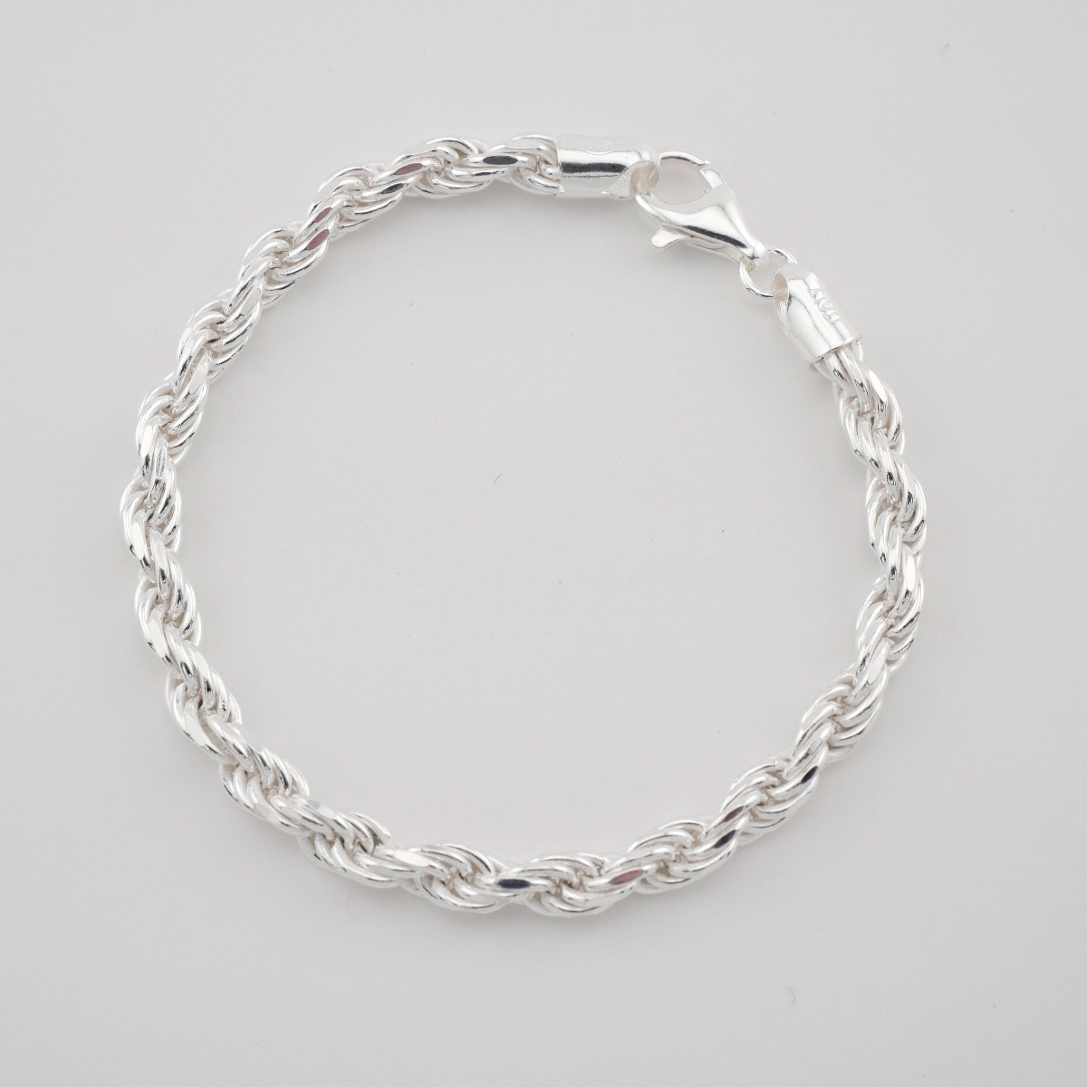 Silver braided bracelet on a light gray background