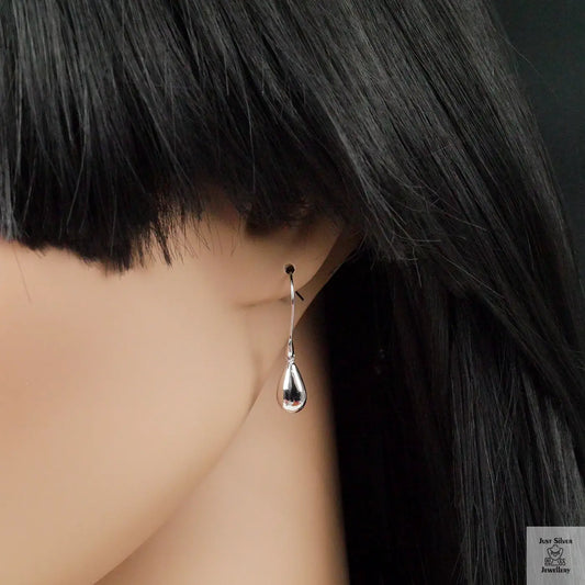 Silver teardrop earring on a mannequin with black hair