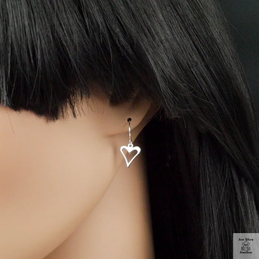Heart-shaped earring worn by a person with black hair.
