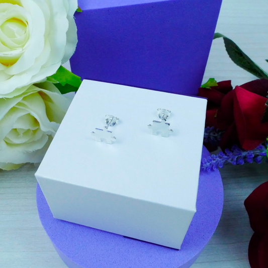 Silver earrings in a white box with flowers in the background