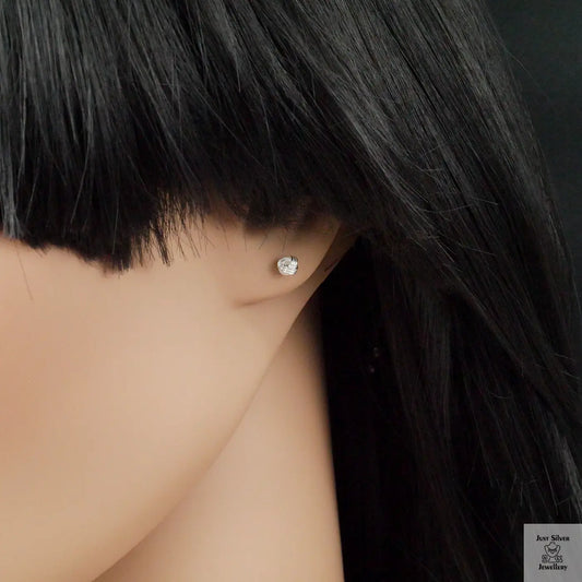 Close-up of a person wearing a silver earring with a dark wig.
