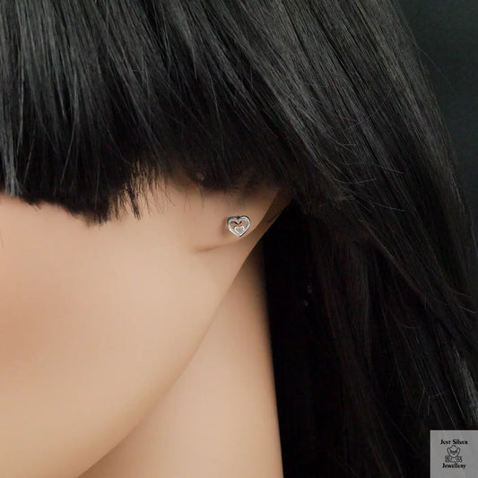 Heart-shaped earring worn by a person with black hair