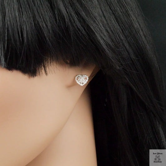 Heart-shaped earring worn by a person with black hair