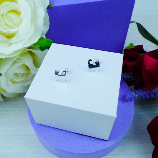 Jewelry box with earrings on a purple stand, surrounded by flowers.