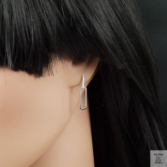 Silver hoop earrings worn by a person with black hair.
