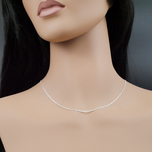 Silver necklace on a mannequin with a plain background