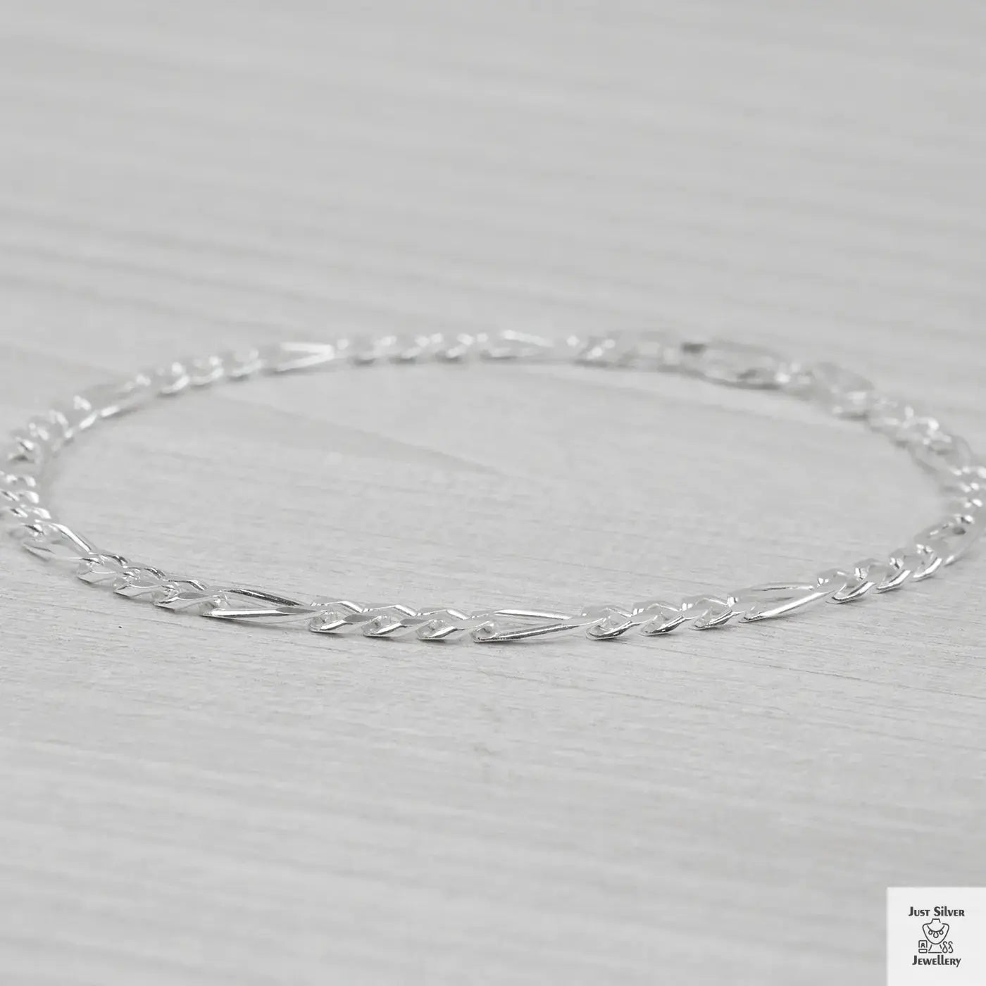 Silver bracelet on a light grey background