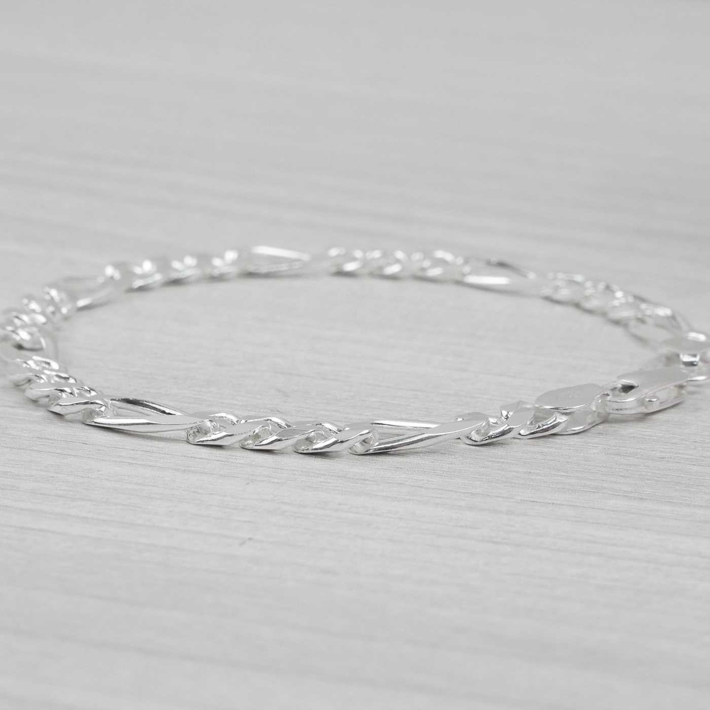 Silver bracelet on a light grey background
