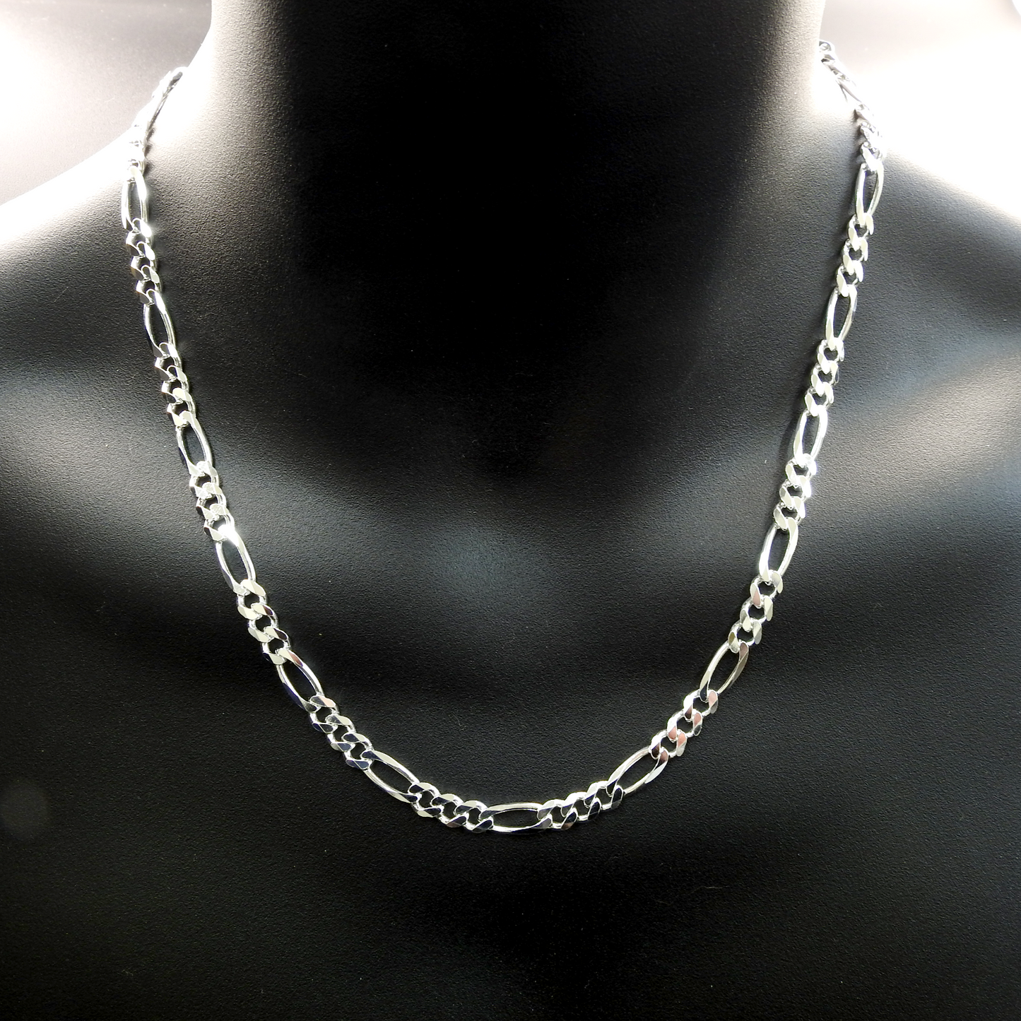 Silver chain necklace on a black mannequin bust.