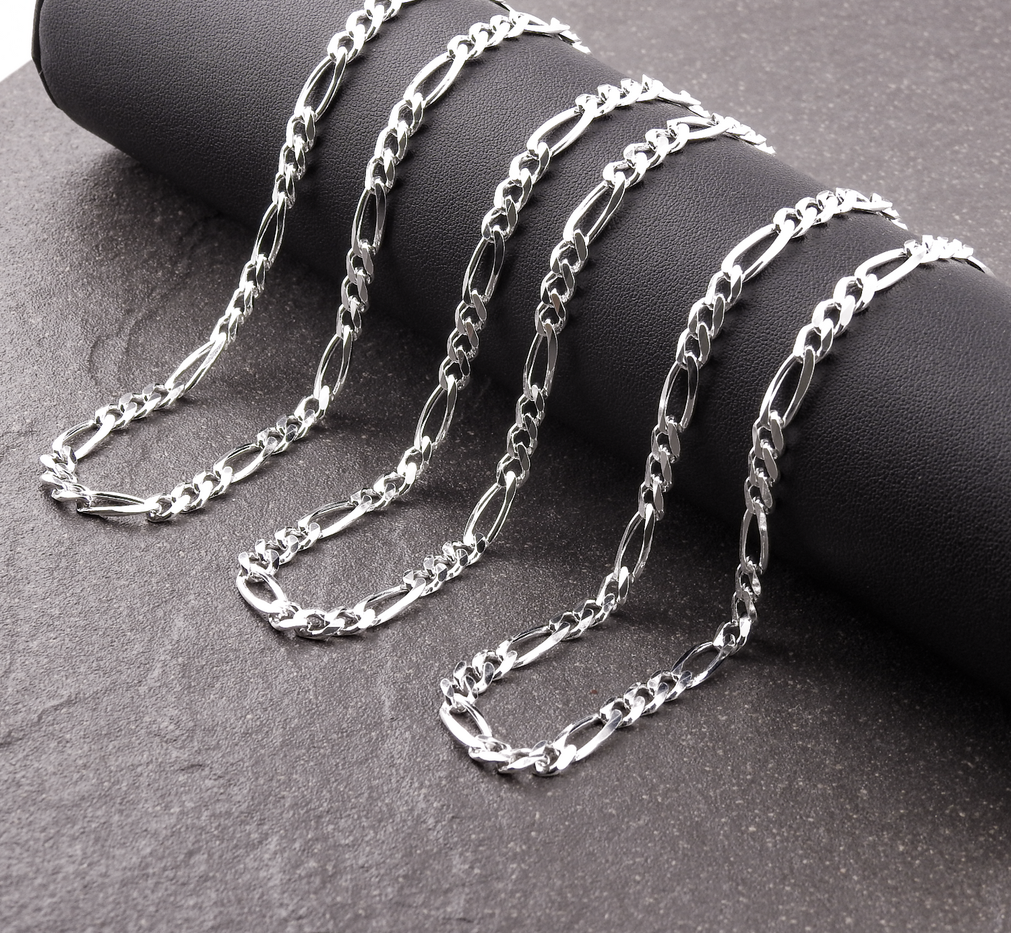Silver chain necklace on a dark surface