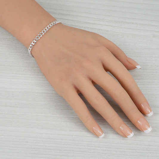 Hand wearing a silver bracelet on a light gray background
