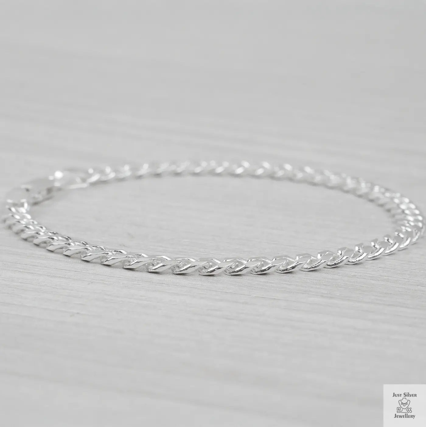 Silver curb bracelet on a light gray background