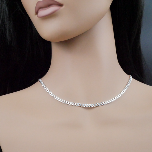 Silver chain necklace on a mannequin with a dark background