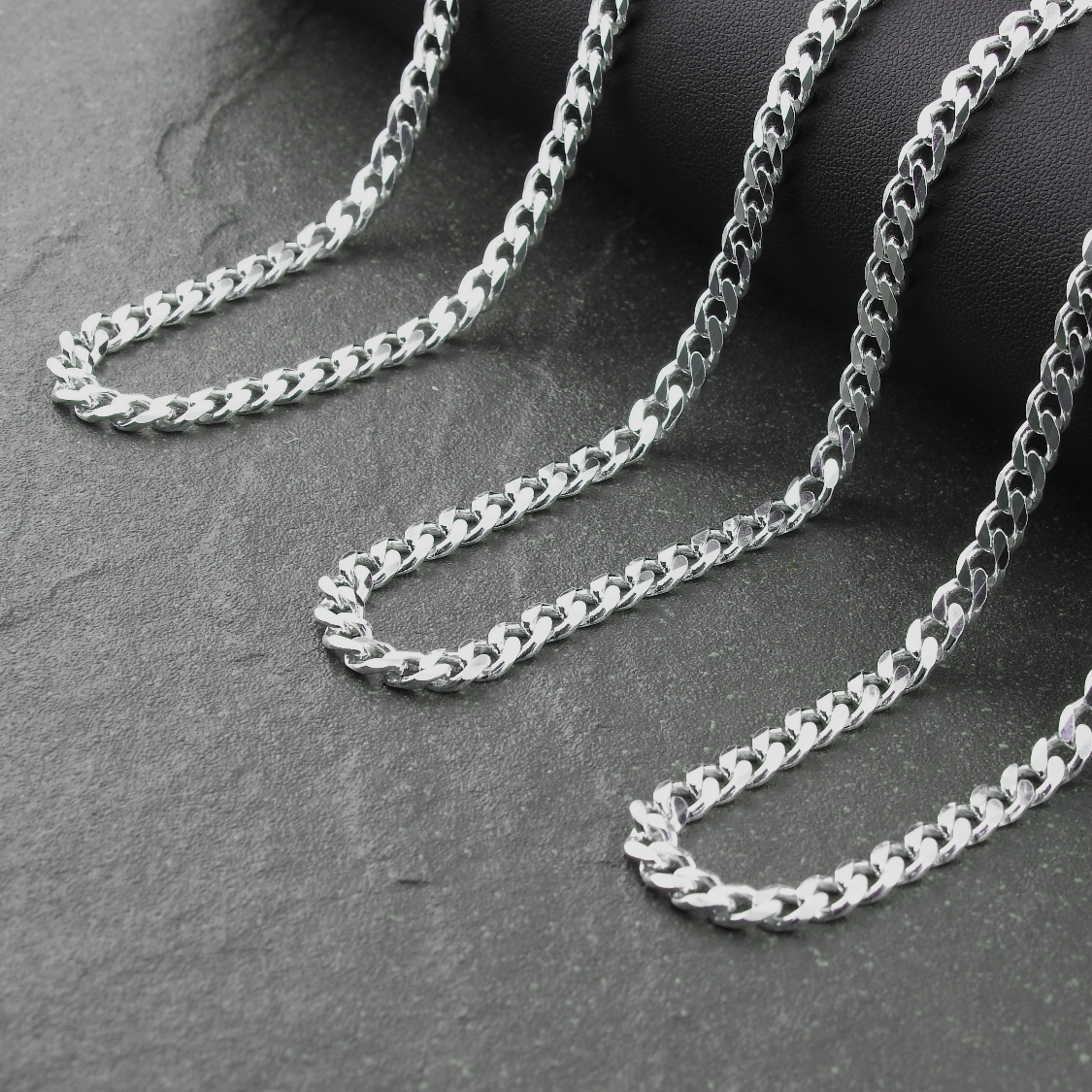 Silver chain on a dark gray surface