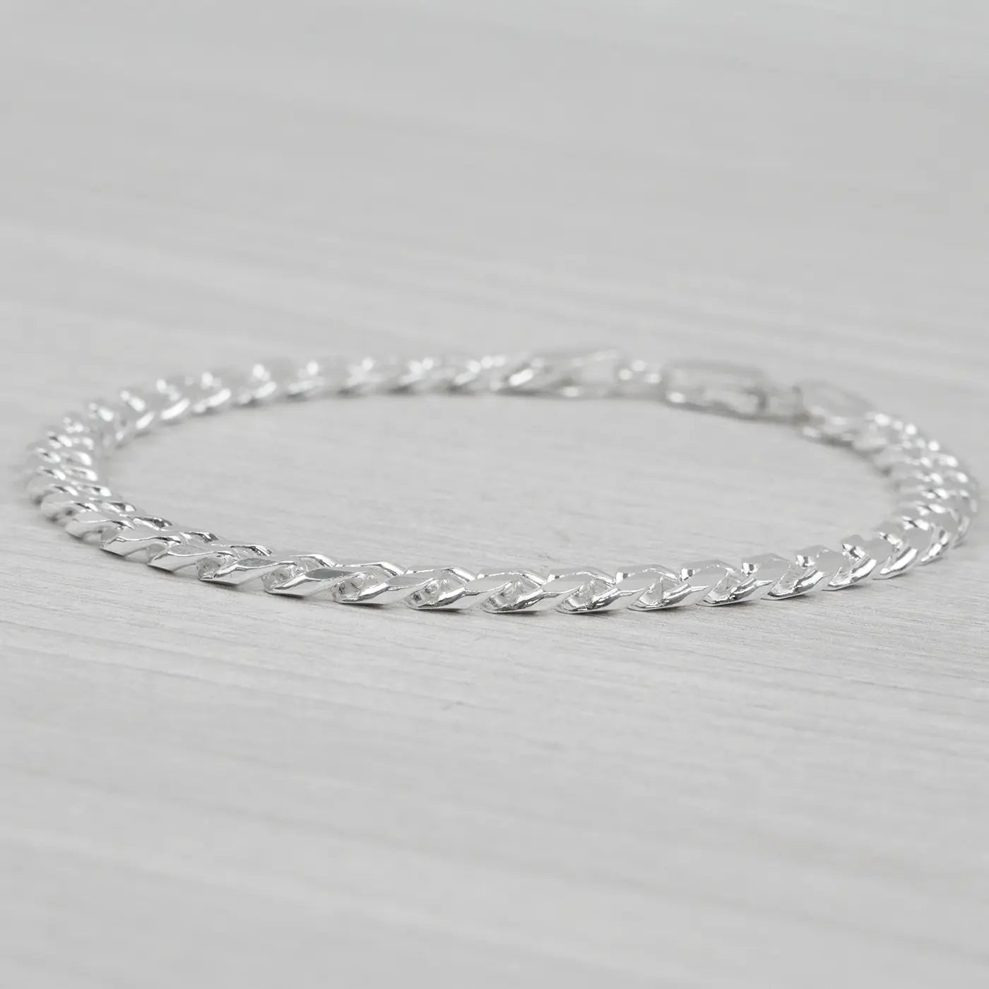 Silver bracelet on a light grey background