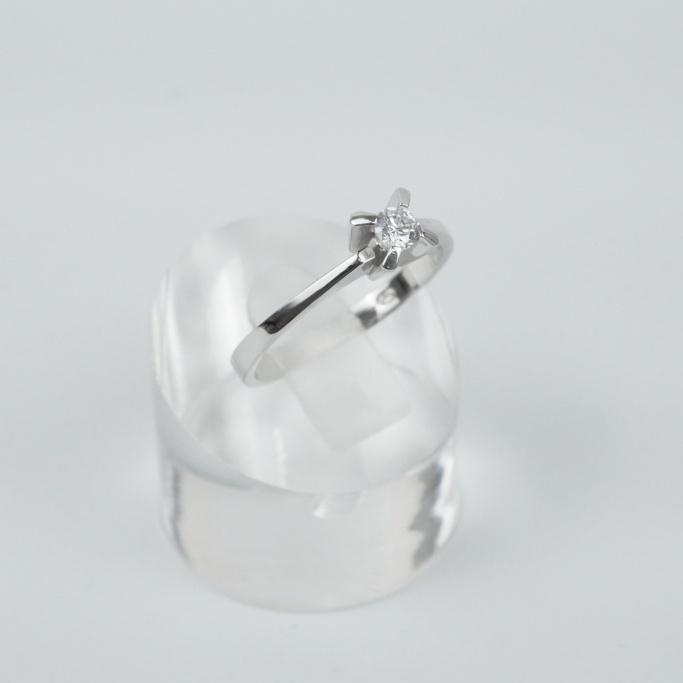 Silver ring with a CZ on a light gray background