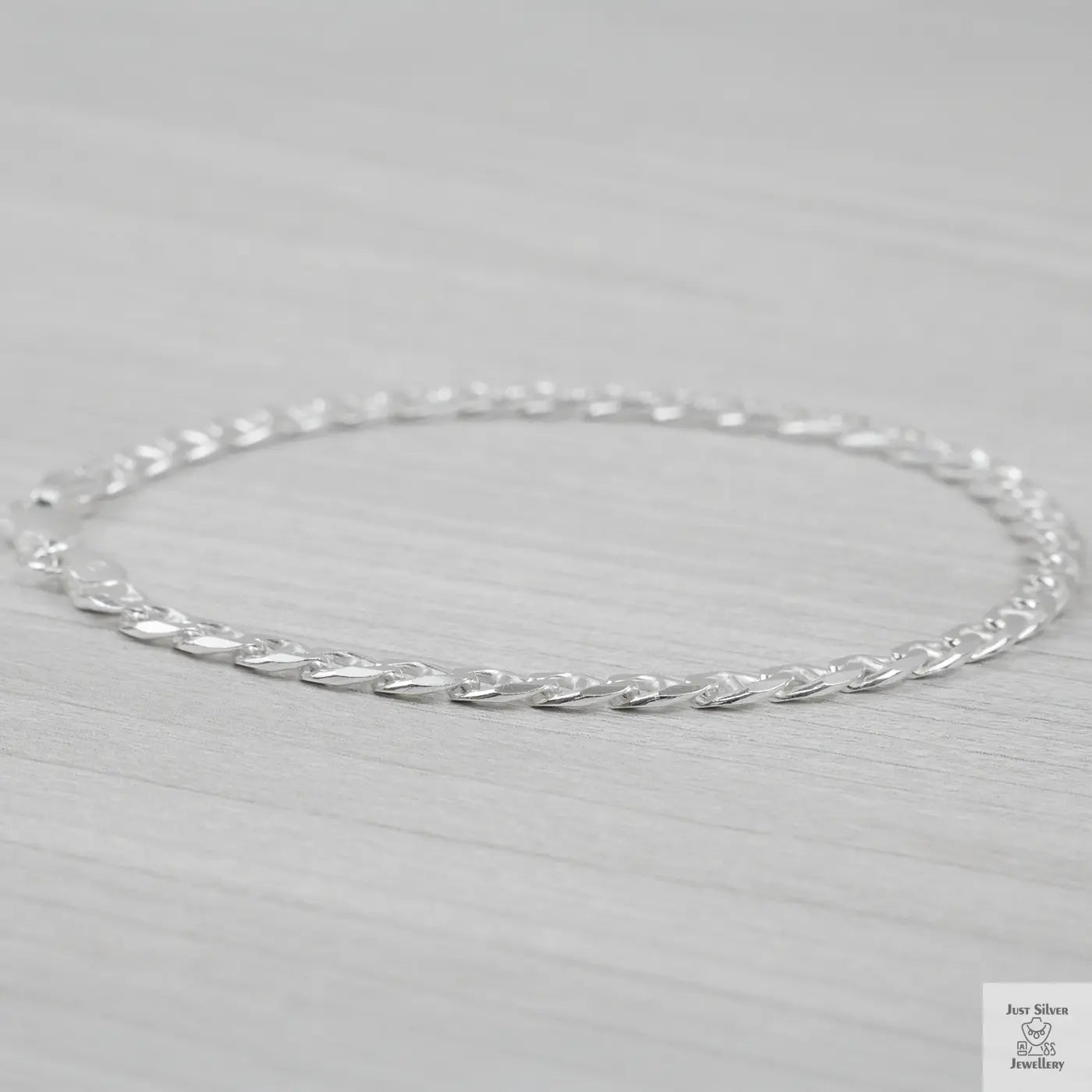 Silver marina link bracelet on a light gray background