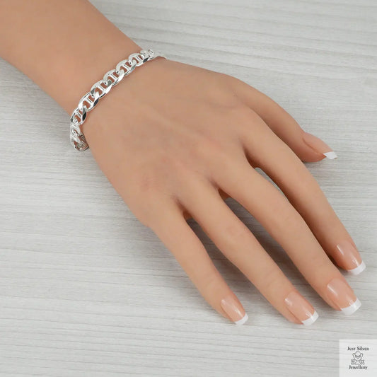 Silver chain bracelet on a hand with a neutral background