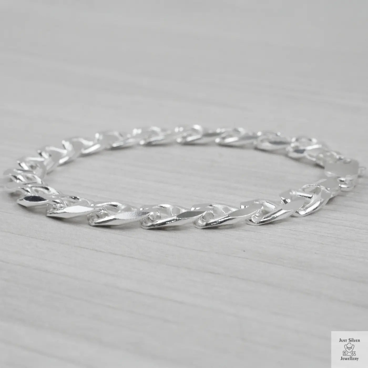 Silver bracelet on a light grey background