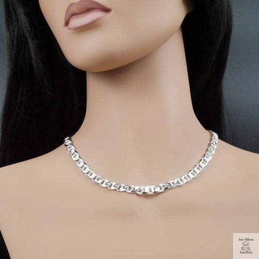 Silver chain necklace on a mannequin with a plain background
