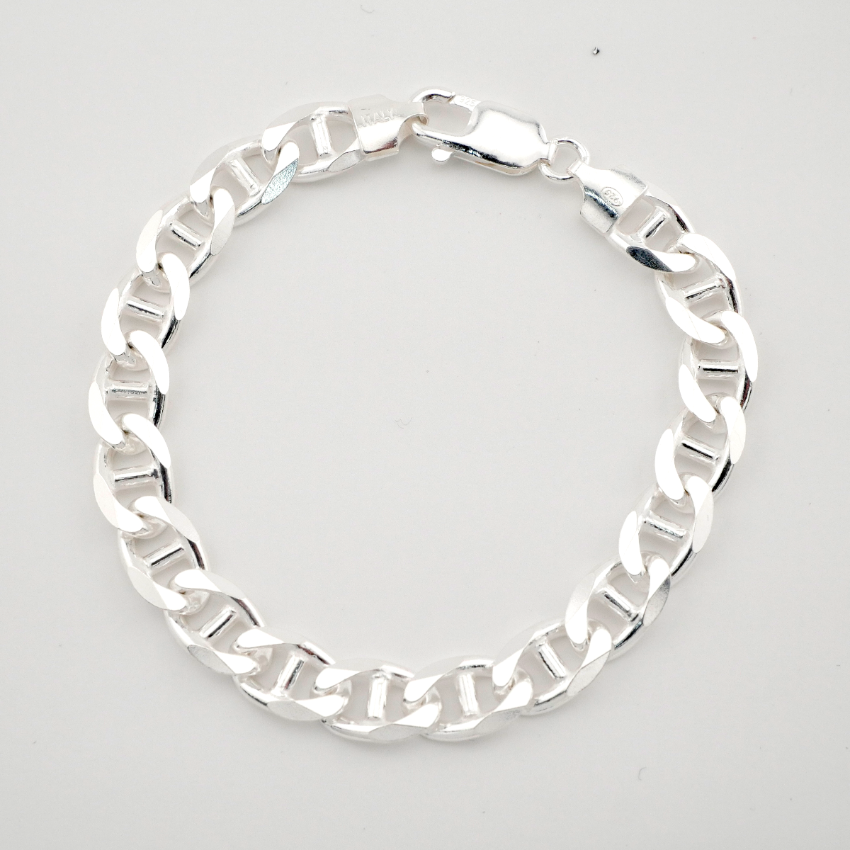 Silver chain bracelet on a light gray background