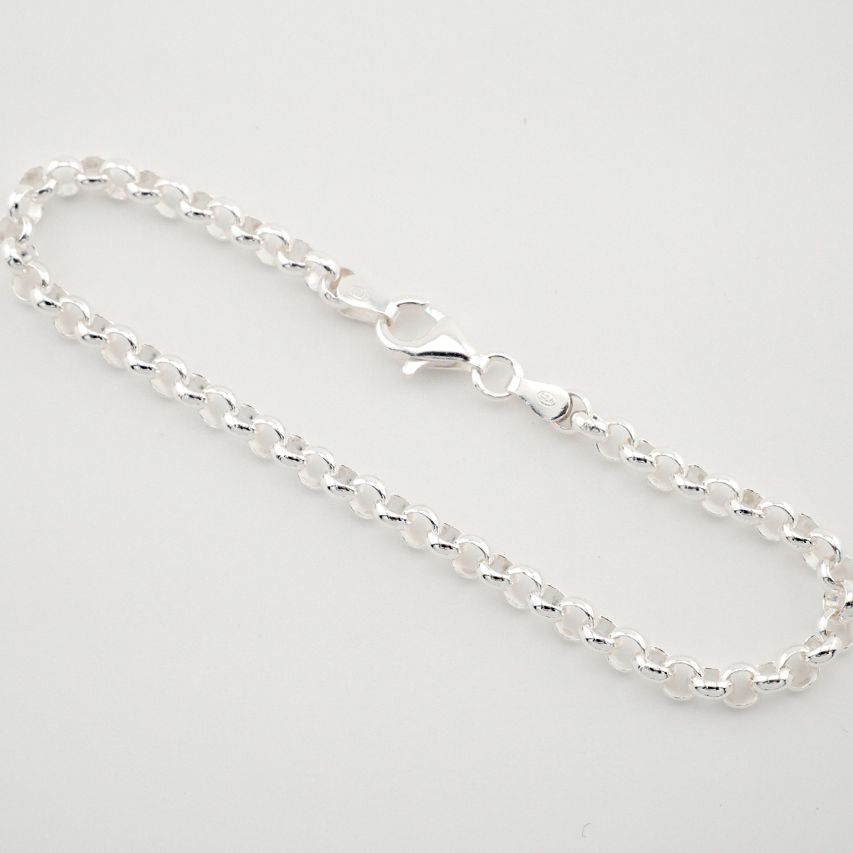 Silver chain bracelet on a light gray background
