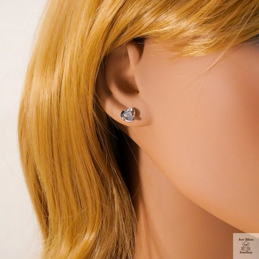 Close-up of a person wearing a silver earring with blonde hair.