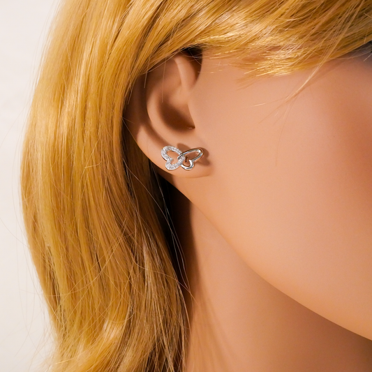 Butterfly-shaped earring worn by a mannequin with blonde hair.