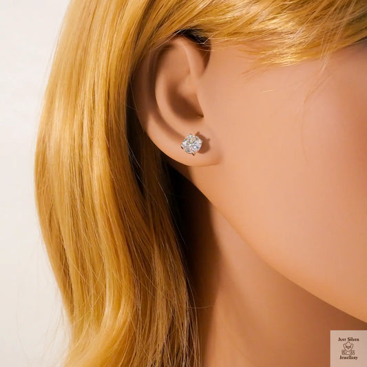 Close-up of an ear wearing a natural zircon stud earring with blonde hair.