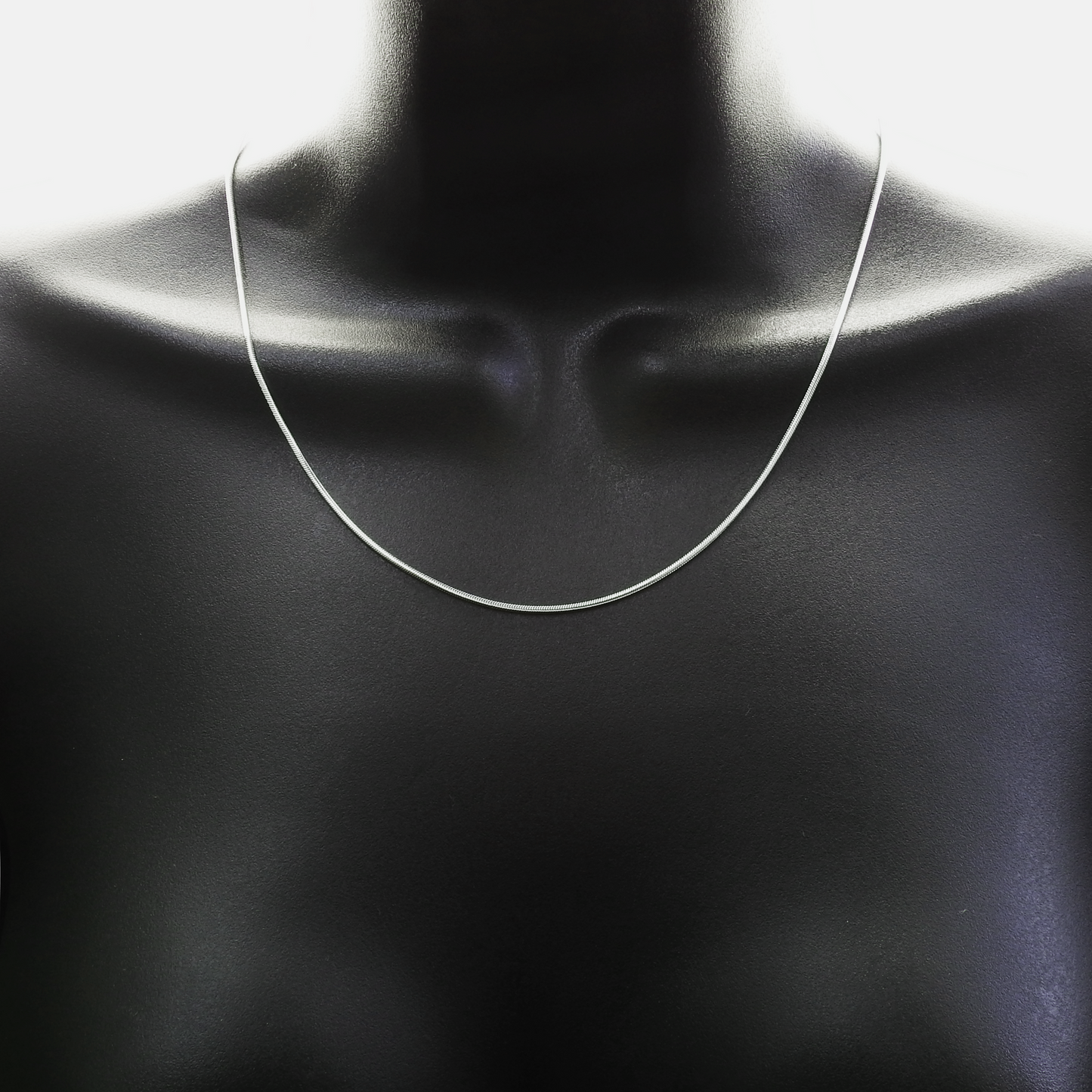 Mannequin wearing a silver necklace against a white background