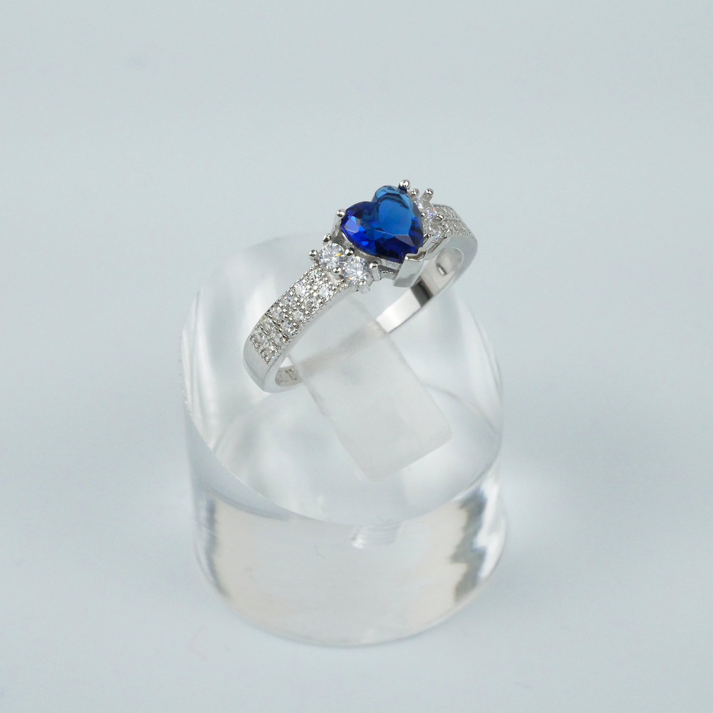 Silver ring with a blue heart-shaped gemstone on a white background