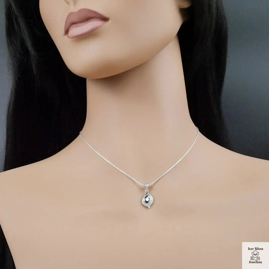 Mannequin wearing a silver necklace with a pendant on a dark background