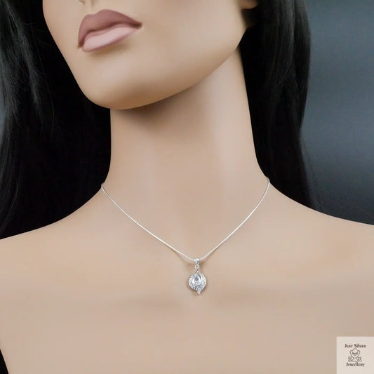 Mannequin wearing a silver necklace with a teardrop pendant on a dark background