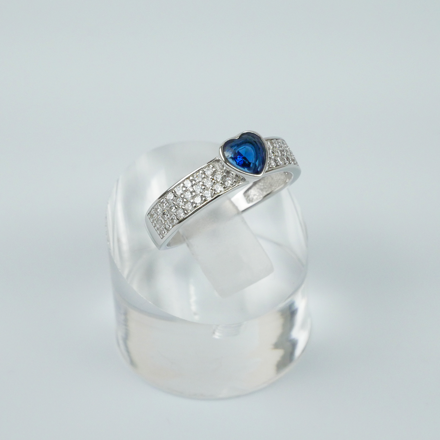 Silver ring with a blue gemstone on a light gray background