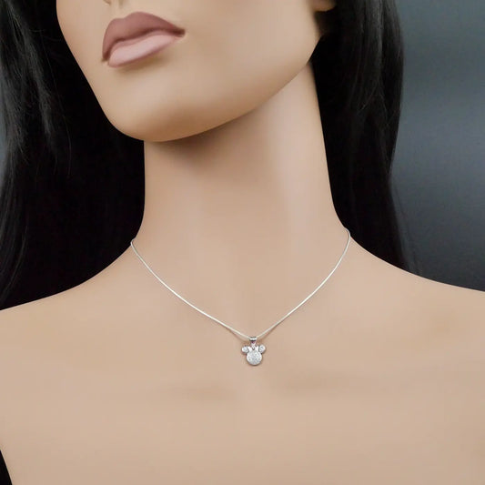 Mannequin wearing a silver necklace with a mouse-shaped pendant on a dark background