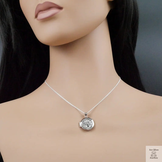 Silver necklace with a round pendant on a mannequin against a dark background