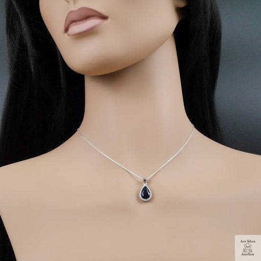 Mannequin wearing a silver necklace with a teardrop-shaped pendant on a dark background