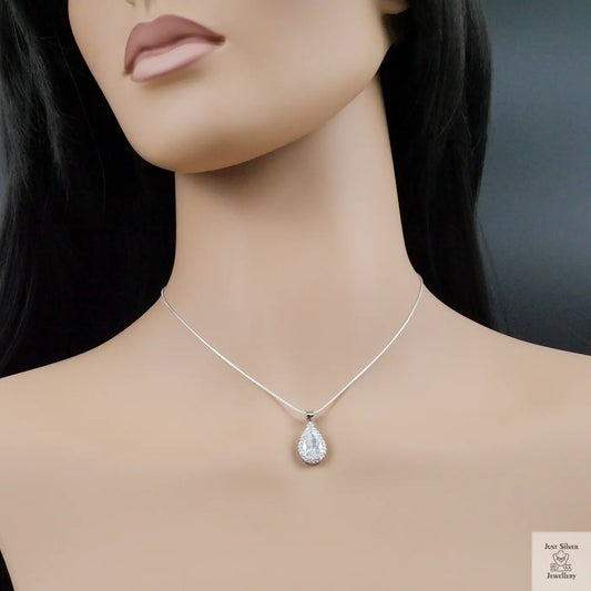 Mannequin wearing a silver teardrop necklace against a dark background