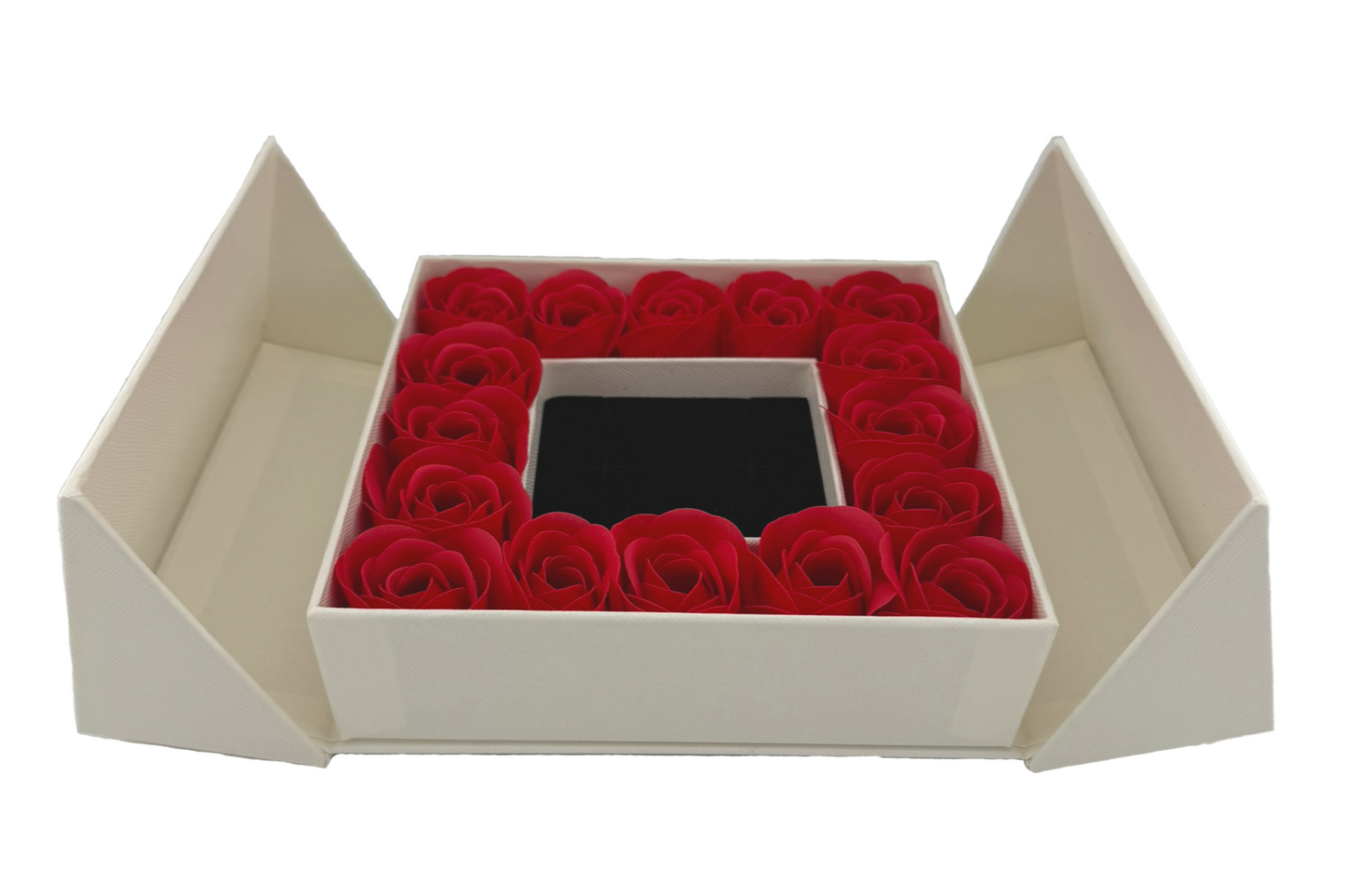 A luxury gift box with a flip-top lid, containing a ring of red roses around a jewelry box with a bow on top.