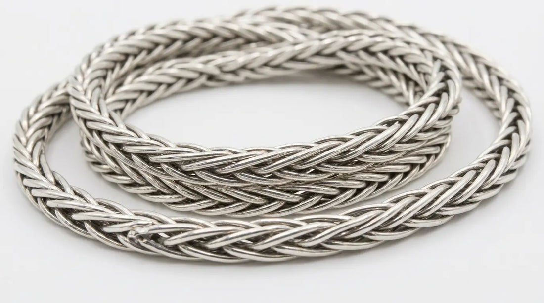 Close-up of a sterling silver foxtail chain necklace showing its densely woven, braided link texture